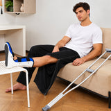 1. Man wearing HAXOR tear away pants while seated with leg brace for recovery